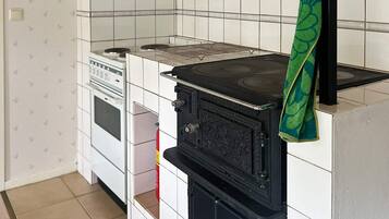 A kitchen with a stove, oven, and a towel hanging on the oven handle.