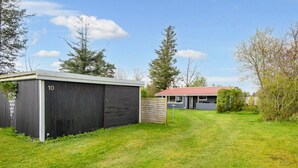 A residential property with a detached house, a garage, and a well-maintained lawn. - 5 Person Holiday Home in Tarm (Tarm)