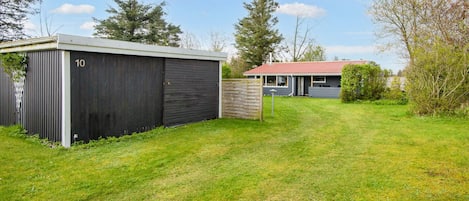 A residential property with a detached house, a garage, and a well-maintained lawn.