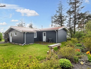 A two-story cabin with a covered patio and a small garden area. - 5 Person Holiday Home in Tarm (Tarm)