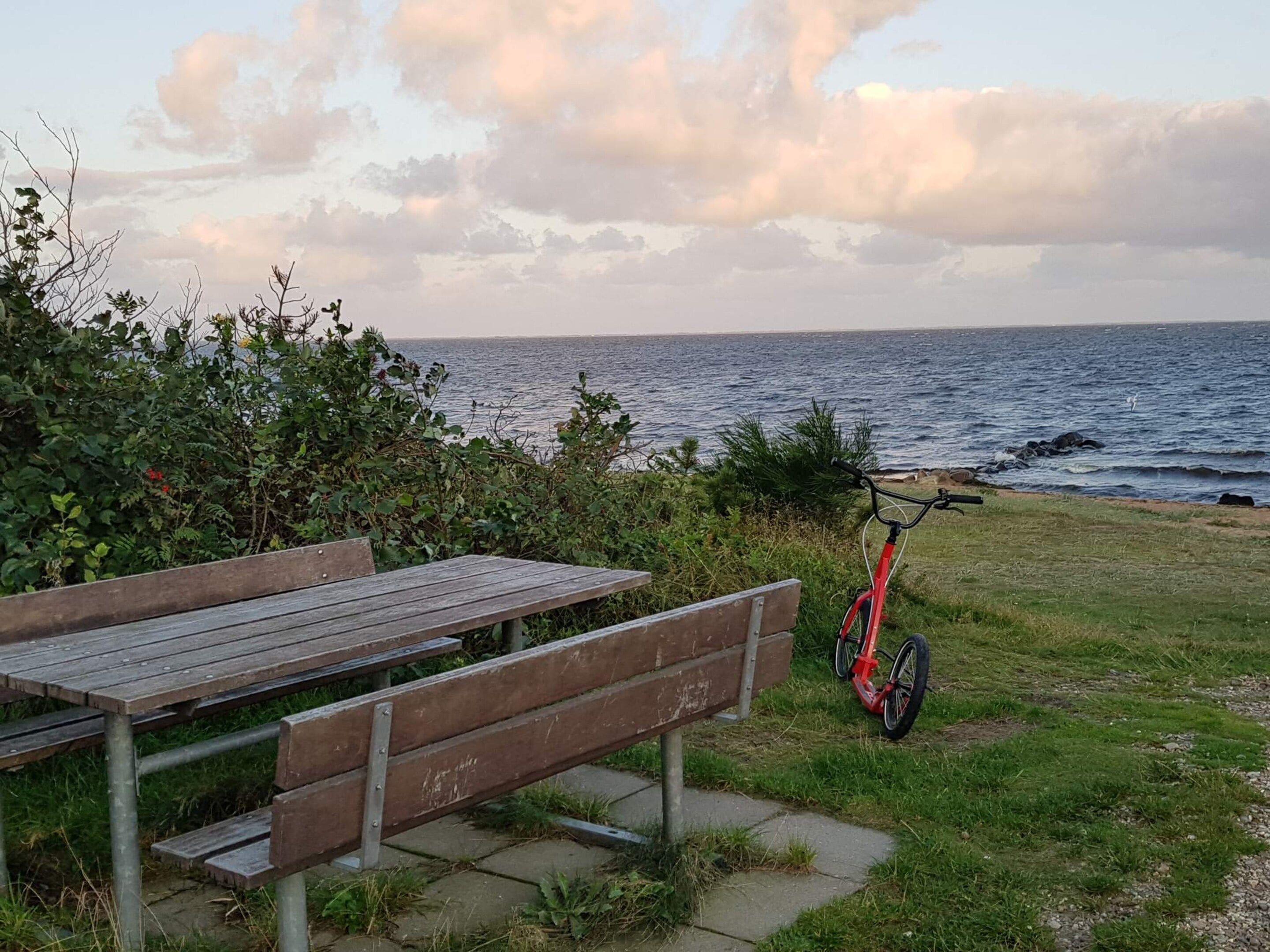 Een houten bankje en een fiets aan de kust.