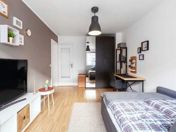 A modern, compact bedroom with a bed, a desk, and a TV. - Modern Apartment With 2 Living Rooms (Heilbronn)