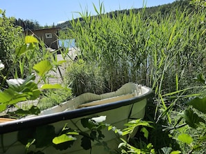 A boat partially submerged in water, surrounded by dense vegetation. - 4 Person Holiday Home in Asarum (Asarum)