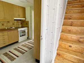 Una cocina con armarios de madera, una estufa y un tapete estampado.