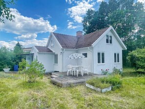 Une maison à deux étages avec un patio couvert et une petite terrasse.