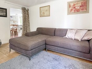 A living room with a sectional sofa, a grey rug, and a dining area visible through an open door. - 5 Person Holiday Home in Bockara (Bockara)