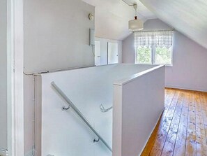 A room with a sloped ceiling, a window with a curtain, and a wooden floor. - 5 Person Holiday Home in Bockara (Bockara)