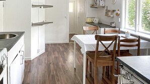 Een keuken met een eethoek, houten vloeren en een raam met uitzicht.