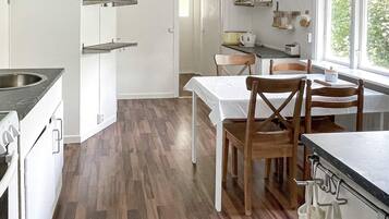 Una cocina con comedor, suelo de madera y ventana con vistas.