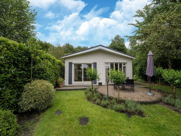 Una casa moderna con un patio, rodeada de abundante vegetación.