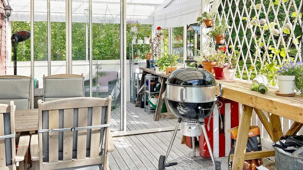 An outdoor patio with wooden furniture, a grill, and potted plants. - 5 Person Holiday Home in Sodertalje (Sodertalje)
