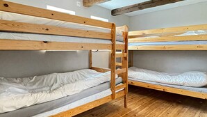 A bunk bed room with wooden frames and grey bedding. - 8 Person Holiday Home in Skivarp (Skivarp)