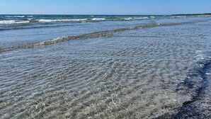 En strand med klart vatten och vågor.