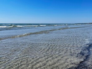 En strand med klart vatten och vågor.