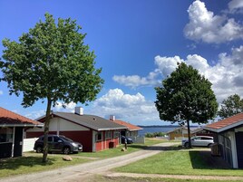 A residential area with houses, a dirt road, and trees.