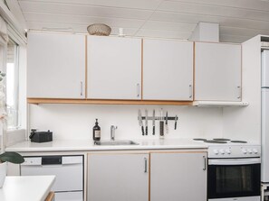 A kitchen with white cabinets, a sink, a stove, and a dishwasher. - 5 Person Holiday Home in Aabenraa (Aabenraa)
