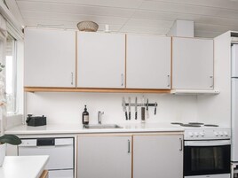 A kitchen with white cabinets, a sink, a stove, and a dishwasher.