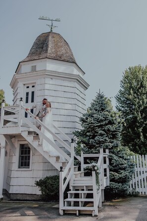 Un bâtiment blanc doté d’une tour, d’un escalier et d’une clôture.