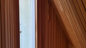 A hallway with wooden paneling and a door leading to a room with white tiled walls. - Borkum Ideal 71 A Comfortable Holiday Residence (Borkum)