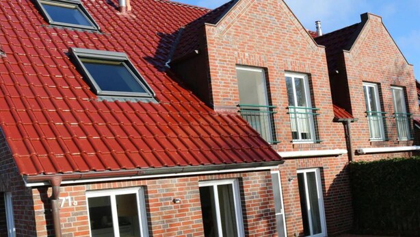 A red-tiled roof, brick exterior, and sliding glass doors of a residential building. - Borkum Ideal 71 A Comfortable Holiday Residence (Borkum)