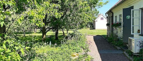A pathway leading to a building with a white exterior and a green sign.