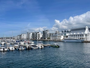 A marina with various boats docked, modern buildings, and a large yacht. - 6 Person Holiday Home in Kattarp (Kattarp)