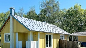 A single-story yellow building with a gabled roof, a front porch, and a wooden fence. - 4 Star Holiday Home in Skummeslovsstrand (Skummesloevsstrand)