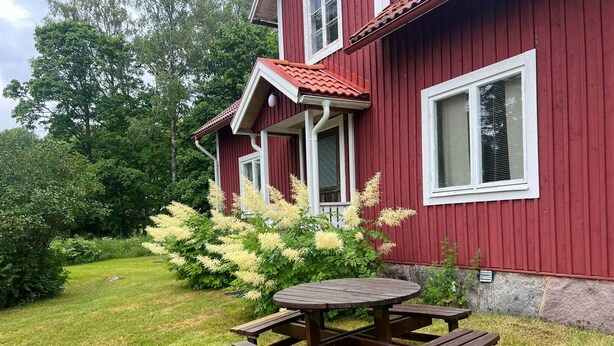 A red wooden house with a red roof, a white window frame, and a garden with a wooden picnic table. - 6 Person Holiday Home in Tingsryd (Tingsryd)