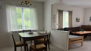 A room with a dining table, chairs, a sofa, and a bed. - 6 Person Holiday Home in Tingsryd (Tingsryd)