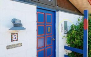 A building with a blue door, a number '3' sign, and a small window with a light fixture. - 5 Person Holiday Home in Frederiksvaerk (Frederiksvaerk)