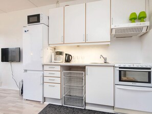 Una piccola cucina accessoriata con forno a microonde, macchina del caffè e forno.