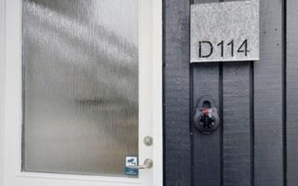 A door with frosted glass and a keypad lock. A sign with 'D114' is mounted on the wall. - 2 Person Holiday Home in Ringkobing (Ringkobing)
