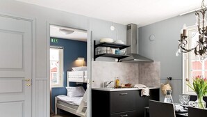 Una cocina compacta con cama, zona de comedor y vistas al exterior.
