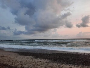 A beach with waves, a cloudy sky, and a distant horizon. - 5 Star Holiday Home in Vestervig (Vestervig)