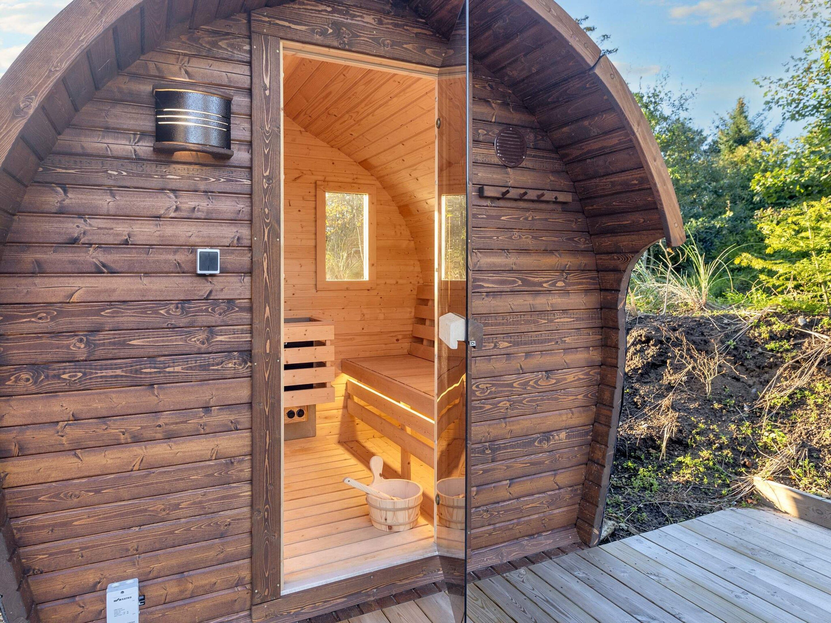 Una sauna de madera con un banco, una ventana y una puerta.