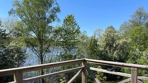 A wooden deck with a view of a lake and trees. - 4 Star Holiday Home in Sparreholm (Sparreholm)