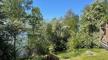 A natural landscape with a wooden cabin and a lake.