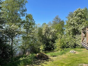 Un paysage naturel avec un chalet en bois et un lac.