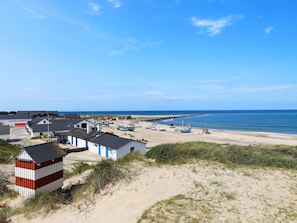 A coastal village with buildings, boats, and a sandy beach. - 4 Person Holiday Home in Thisted (Thisted)