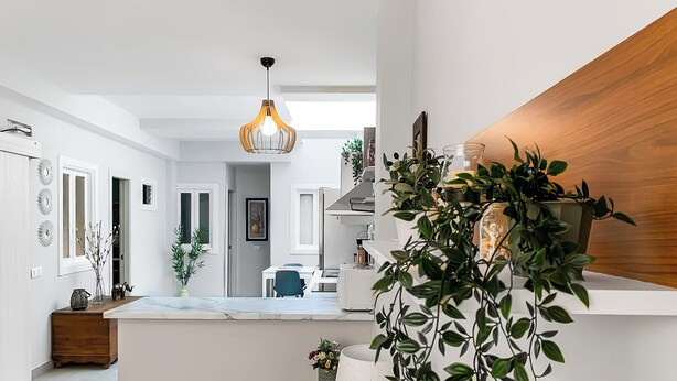 A modern kitchen with a wooden countertop, a hanging pendant light, and various potted plants. - Beachhouse Gran Tarajal 3BR (Gran Tarajal)