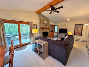 Relax in this inviting living room with a sectional sofa, flat-screen TV, and stone fireplace.