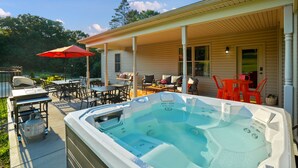 A covered outdoor area with a hot tub, patio furniture, and a barbecue grill. - Espolon Ranch | 5BR, Pool, & Pickleball (New Plymouth)