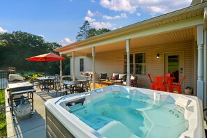 A covered outdoor area with a hot tub, patio furniture, and a barbecue grill. - Espolon Ranch | 5BR, Pool, & Pickleball (New Plymouth)