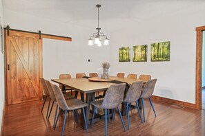 Un comedor con una mesa de madera, sillas y una lámpara colgante.