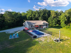 A house with a swimming pool, outdoor furniture, and a covered patio area.