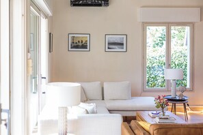 Relax in this inviting living space with a plush sofa, side table, and serene views of the outdoors.