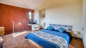 Un dormitorio con cama, una escalera y vistas al exterior.