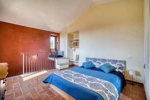 Un dormitorio con cama, una escalera y vistas al exterior.