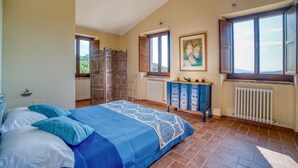 Una camera da letto con un letto, una cassettiera, un termosifone e una finestra.