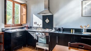 Una cocina moderna con estufa, horno y un amplio ventanal.
